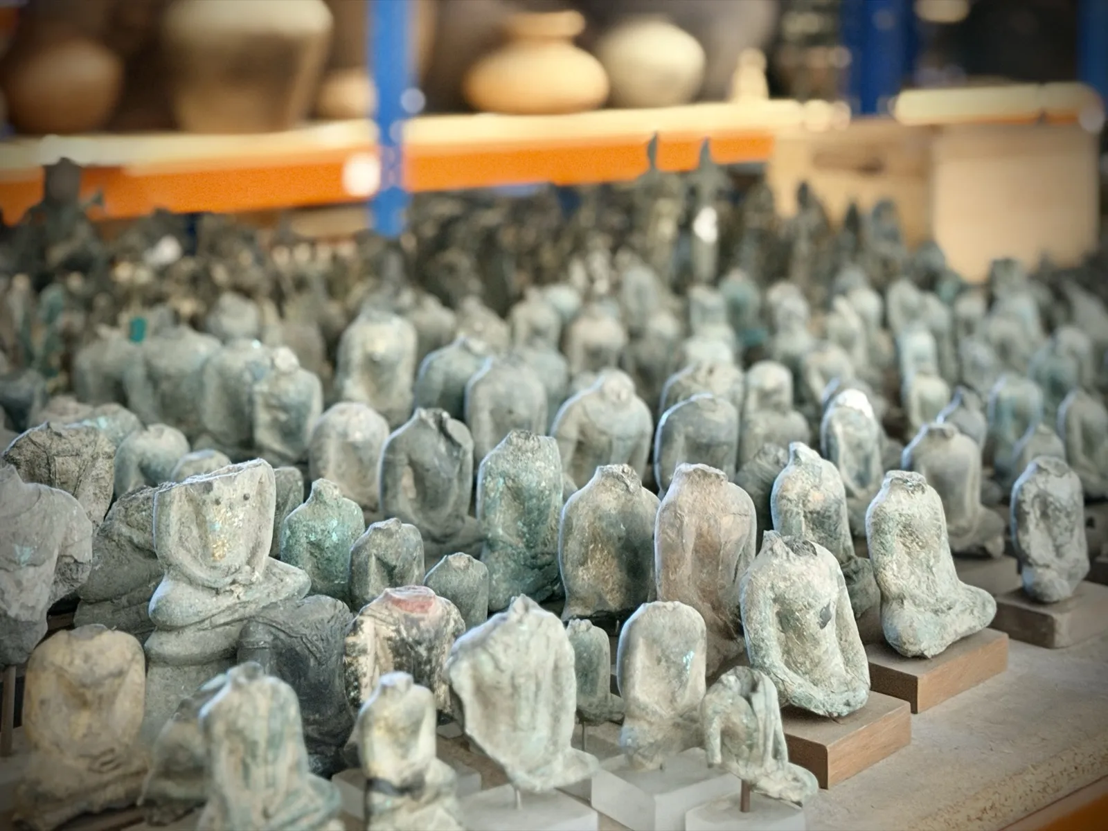 Hundreds of small bronze Buddha figures arranged in rows
